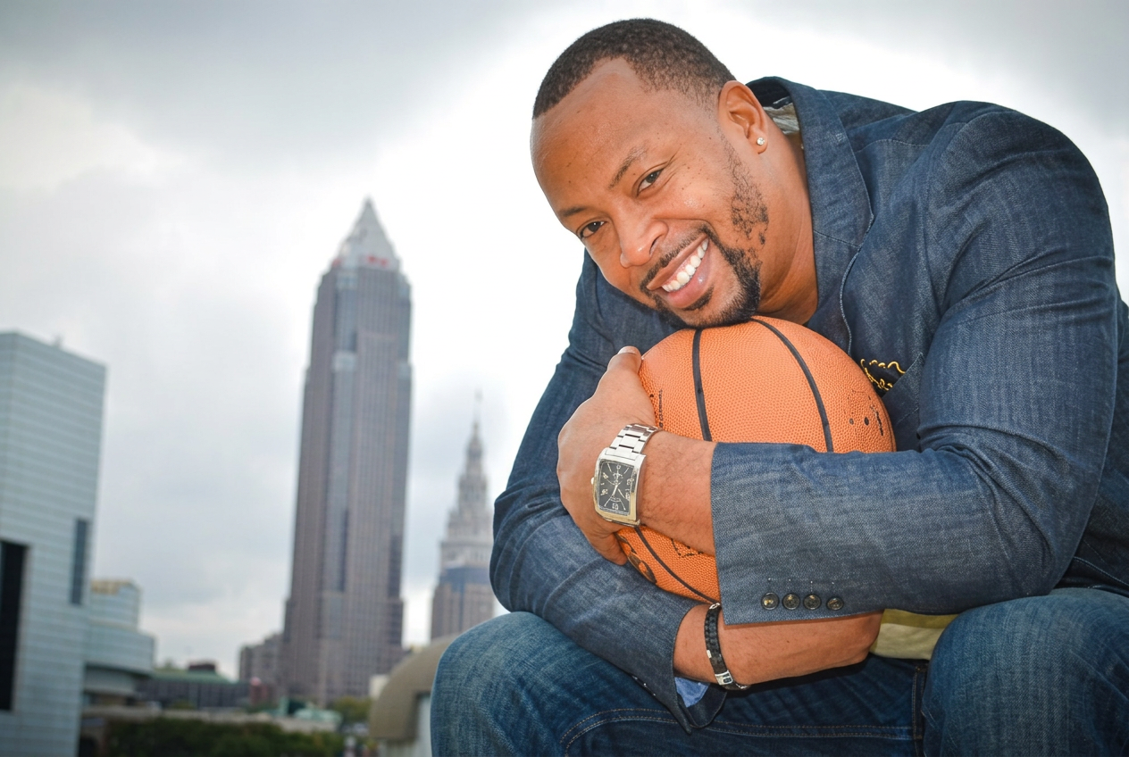 Dr. Wesley Fluellen, Sr. holding a basketball, Cleveland skyline behind
